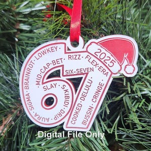 Könnte beinhalten: Weiß-roter Weihnachtsschmuck mit der Zahl 67 und dem Jahr 2025. Der Schmuck hat einen Weihnachtsmannhut und verschiedene Slang-Begriffe. Ein rotes Band ist zum Aufhängen befestigt. Der Text "Digital File Only" steht unten.