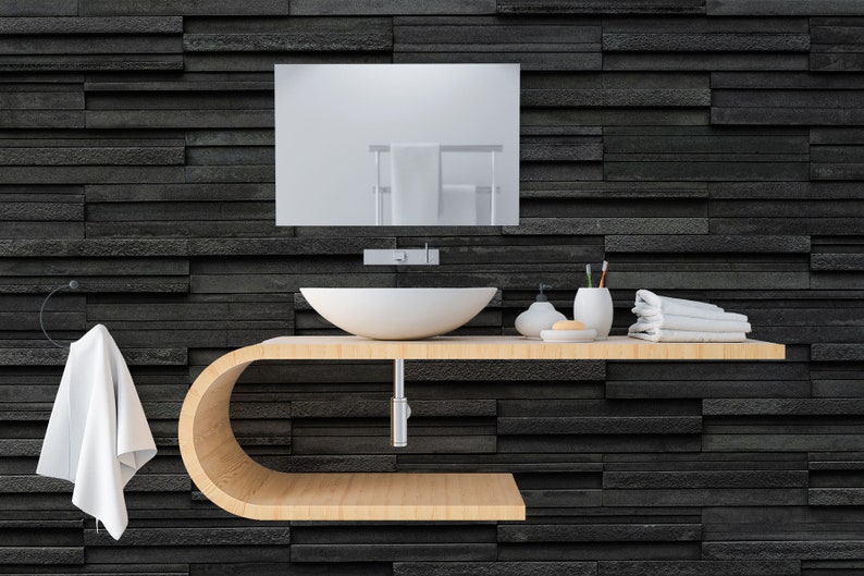 Puede incluir: Un tocador de ba&ntilde;o moderno con un lavabo de cer&aacute;mica blanca, una encimera de madera y un espejo sobre el lavabo. El tocador est&aacute; montado en una pared de azulejos negros.