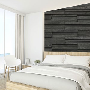 Puede incluir: Un dormitorio blanco con una gran ventana con vistas al oc&eacute;ano. La cama tiene una cabecera blanca y una funda n&oacute;rdica blanca. Una pared de piedra negra est&aacute; detr&aacute;s de la cama. Una silla blanca est&aacute; en la esquina de la habitaci&oacute;n.