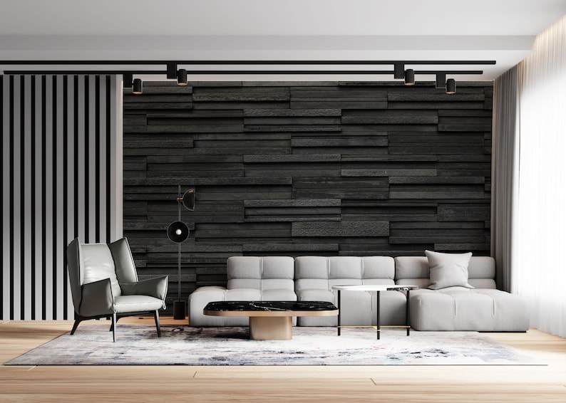 Puede incluir: Un sal&oacute;n moderno con un sof&aacute; de esquina gris, un sill&oacute;n gris y una mesa de centro negra. La pared detr&aacute;s del sof&aacute; est&aacute; cubierta de azulejos de pizarra negra. La habitaci&oacute;n tiene un suelo de madera y una alfombra.