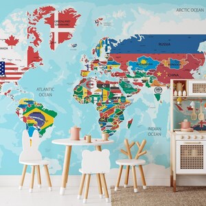 A living room wall decorated with a large, peel and stick world map wallpaper that includes the flags of the world.