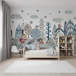 Puede incluir: Un mural de pared con una escena de bosque en acuarela con un oso, un conejo y un ciervo, situado detrás de una estructura de cama de madera y una estantería de seis compartimentos. El diseño incluye nubes grises, estrellas y árboles en tonos azul y verde.