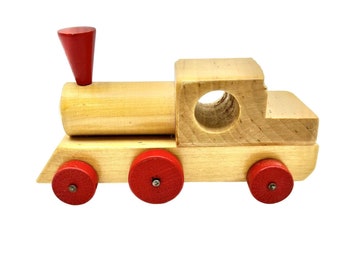 May include: A wooden toy train with red wheels and a red chimney. The train is made of natural wood and has a simple design.