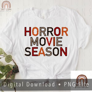 May include: White t-shirt with the text "HORROR MOVIE SEASON" in black letters with a leopard print pattern. The letters are outlined in red.