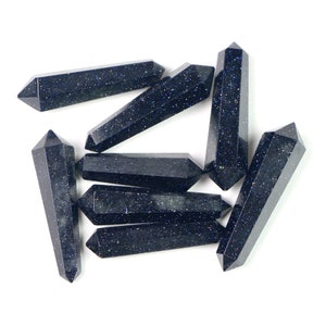 May include: A group of eight blue kyanite crystal points, also known as blue quartz, arranged in a starburst pattern. The points are smooth and polished, with a dark blue color and a slight sparkle.