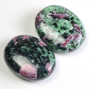 May include: Two smooth, oval-shaped green and pink stones with a speckled pattern. The stones are polished and have a glossy finish.
