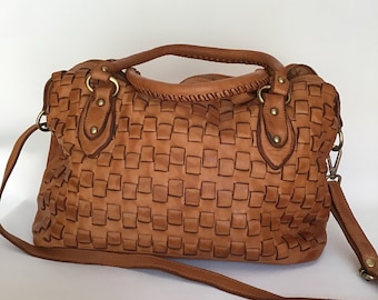 May include: A woven brown leather handbag with a top handle and a long shoulder strap.