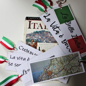 Op de afbeelding: Een set van zes bladwijzers met Italiaanse thema's. De bladwijzers bevatten een kaart van Italië, een boekomslag met het woord "ITAL" erop, en de zinnen "La Bella Italia!" en "La Vita è gen." De bladwijzers zijn versierd met rood-wit-groene linten.