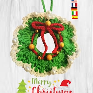 May include: A handmade crochet Christmas wreath with a green base, white and cream trim, and a red bow. The wreath is adorned with gold beads and white pearl-like accents. A green loop is attached for hanging. The words "Merry Christmas" are written below.