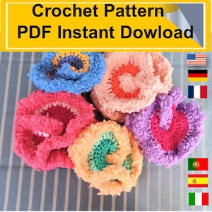 Pode incluir: Cinco esfregões de crochê em forma de flor em diferentes cores: rosa, azul, pêssego, roxo e rosa claro. Cada esfregão tem um centro de cor diferente. Os esfregões estão dispostos em círculo sobre um fundo listrado. Padrão de crochê PDF Download instantâneo.