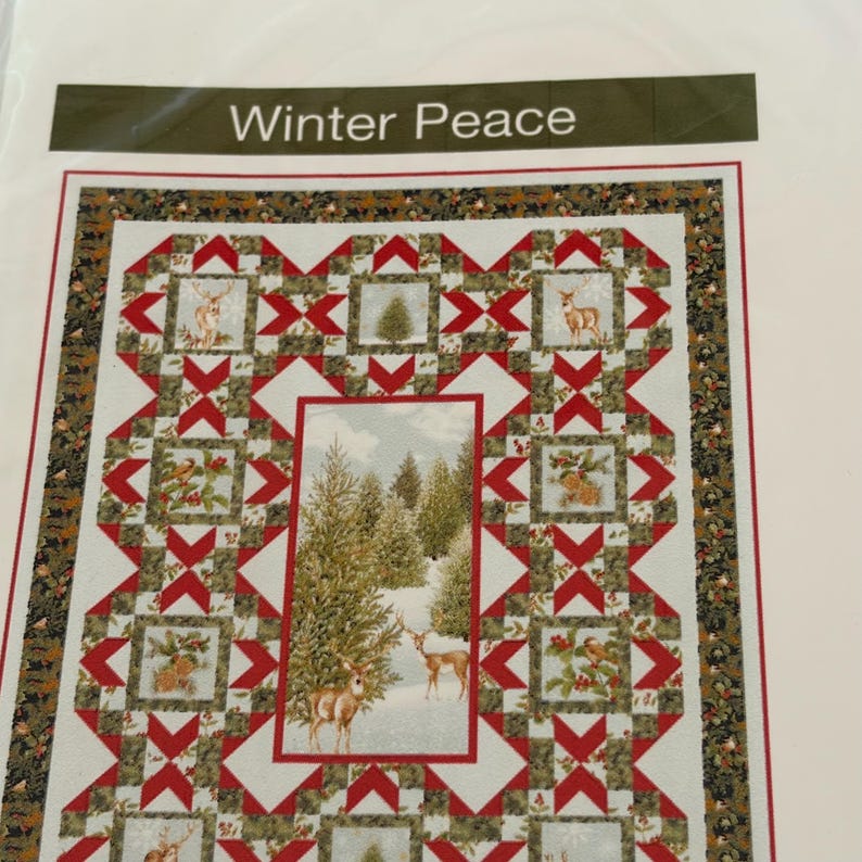 May include: A quilt pattern titled Winter Peace featuring a central rectangular panel of a snowy forest with deer, surrounded by a border of red and white geometric star blocks, green pine foliage, and small square vignettes of deer and birds.