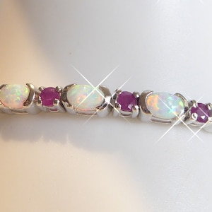 Könnte beinhalten: Ein silbernes Armband mit abwechselnden weißen Opal- und rosafarbenen Rubin-Steinen.