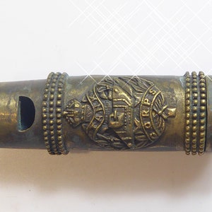 Puede incluir: Un silbato de latón con un diseño decorativo que presenta una corona, un escudo y las palabras "Royal Army Corps".