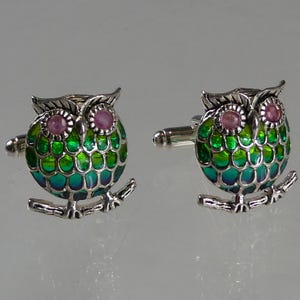Coppia di gemelli a forma di gufo smaltato con occhi di rubino incastonati in argento.