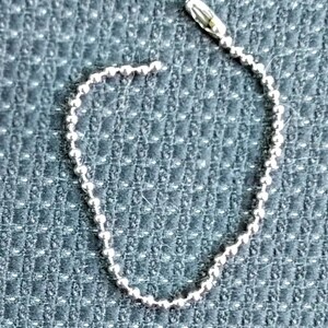 May include: A silver beaded chain with a silver clasp.