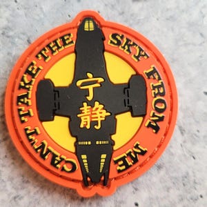 May include: Round orange patch with the text "CAN'T TAKE THE SKY FROM ME" and a black spaceship design. The center features yellow and black accents with Chinese characters. A unique patch for fans of science fiction.
