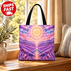 Könnte beinhalten: Eine Tragetasche mit schwarzen Henkeln und einem lebendigen, farbenfrohen Druck eines Lavendelfeldes unter einer strahlenden Sonne. Das Design zeigt violette und rosa Farbtöne in der Landschaft sowie ein kreisförmiges Sonnenmuster am Himmel.