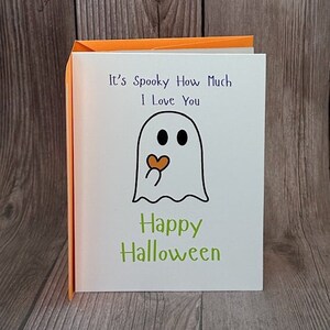 May include: A white card with a ghost holding a heart and the text "It's Spooky How Much I Love You" and "Happy Halloween".
