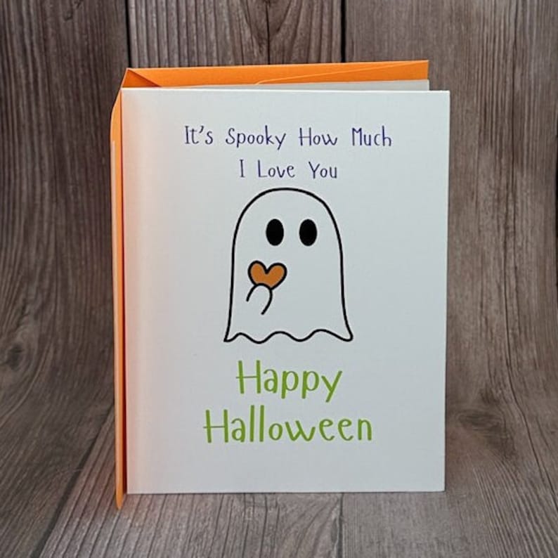 May include: A white card with a ghost holding a heart and the text "It's Spooky How Much I Love You" and "Happy Halloween".