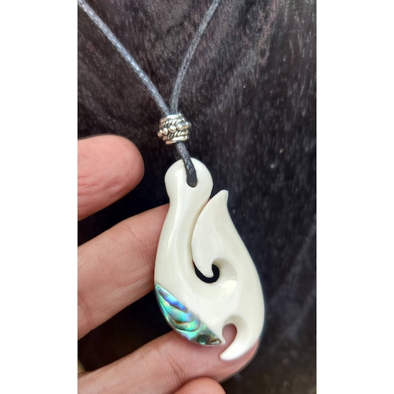HAND CARVED NATURAL BONE HOOK WITH MANAIA FACE PENDANT. BONE HOOK