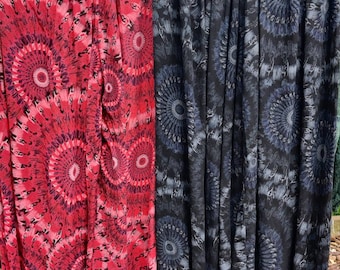 Puede incluir: Dos pares de pantalones harem estampados, uno con un patrón de remolino rojo y rosa y el otro con un patrón de remolino negro y gris.