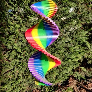 Pu&ograve; includere: Un mulino a vento arcobaleno colorato con tre livelli di lamelle di legno. Il mulino &egrave; sospeso a una corda ed &egrave; progettato per ruotare al vento.
