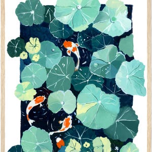May include: A framed art print featuring a pond scene with koi fish and lily pads. The artwork showcases a dark blue pond with green lily pads and orange and white koi fish. The frame is made of light-colored wood.