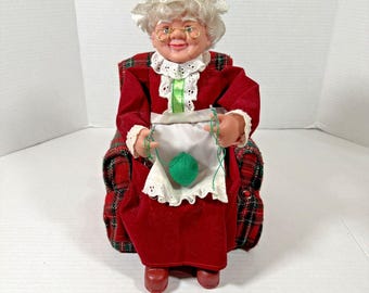 Vídeo animado de tejido de la señora Santa Claus sentada en el sofá VTG