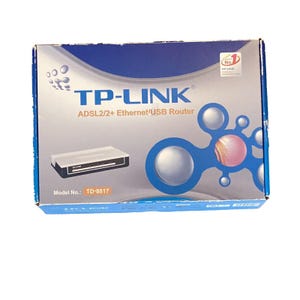 May include: A rectangular cardboard product box for a TP-LINK ADSL2/2+ Ethernet/USB Router, model number TD-8817. The box features a silver and blue design with a graphic of the router and abstract blue circles with a central pink sphere.