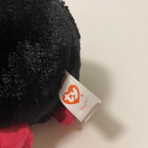 May include: Black plush toy with a red bow and a Ty tag that says "Diaper".