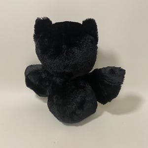 May include: A black plush toy shaped like a bat with large ears and wings.