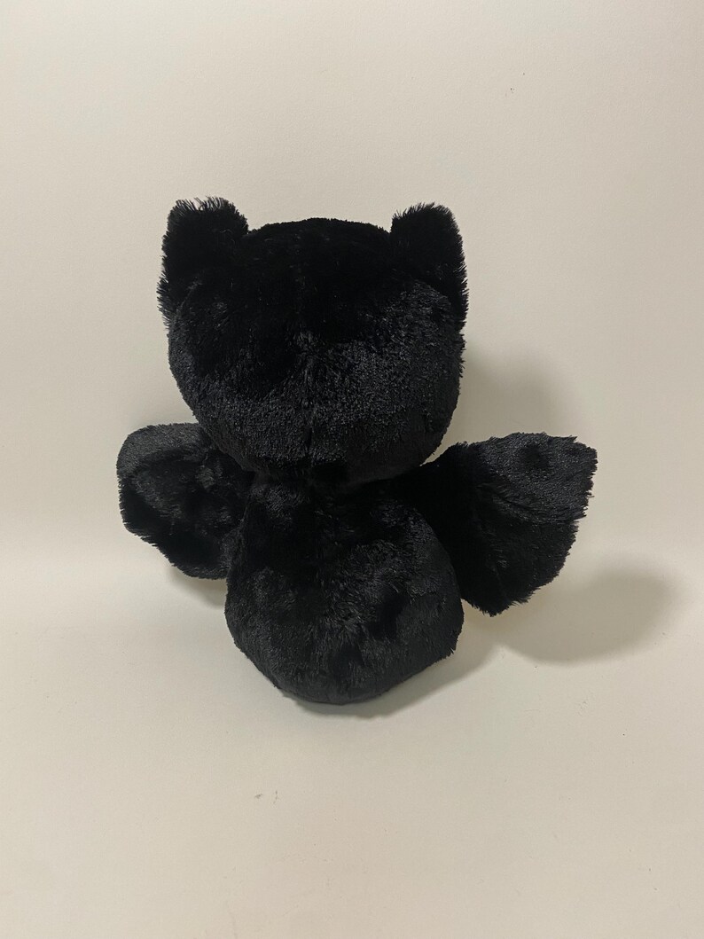 May include: A black plush toy shaped like a bat with large ears and wings.