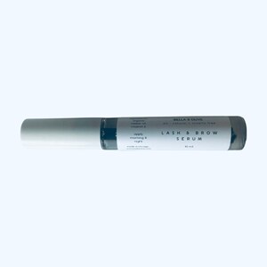 Peut inclure: Un tube blanc et gris avec une &eacute;tiquette noire qui indique "BELLA & OLIVE all-natural cruelty free LASH & BROW SERUM 10 ml".