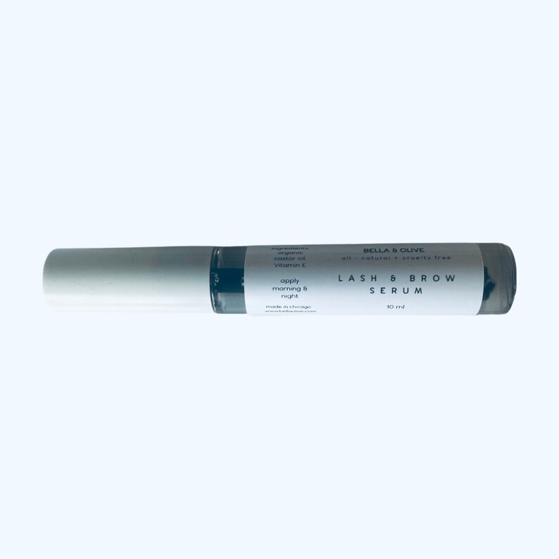 Peut inclure: Un tube blanc et gris avec une &eacute;tiquette noire qui indique "BELLA & OLIVE all-natural cruelty free LASH & BROW SERUM 10 ml".