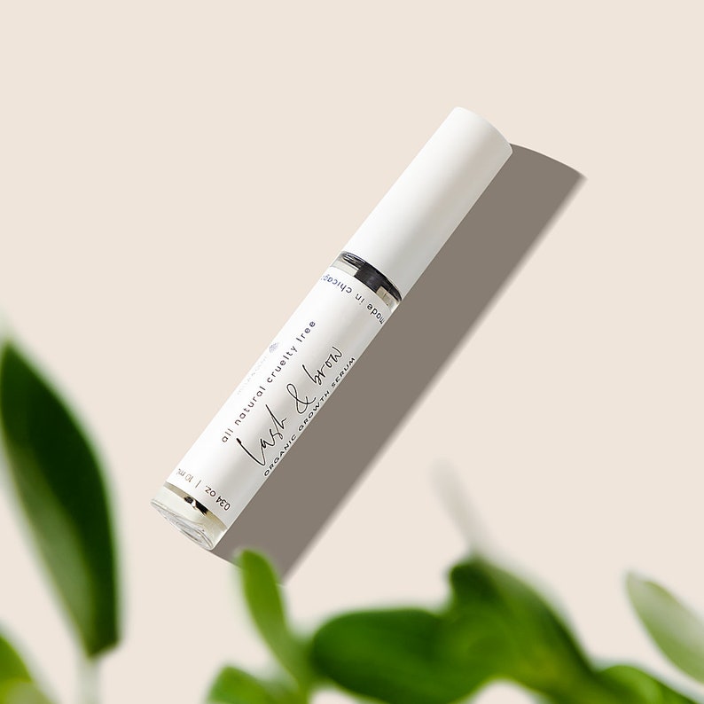 Peut inclure: Un tube blanc avec un capuchon argent&eacute; contenant du s&eacute;rum de croissance biologique pour les cils et les sourcils Lash & Brow. L'&eacute;tiquette est blanche avec du texte noir qui indique "all natural cruelty free Lash & Brow ORGANIC GROWTH SERUM" et "0.34 oz."