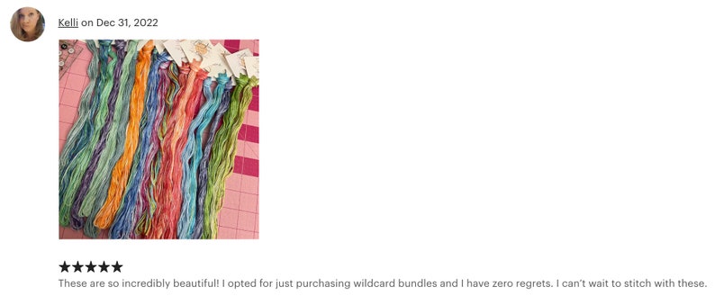 May include: A close-up of a collection of colorful embroidery floss spools. The floss is arranged in a rainbow pattern and is ready for use in a craft project.