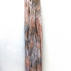 May include: A skein of yarn in shades of brown, blue, and white. The yarn is hand-dyed and has a variegated color pattern.