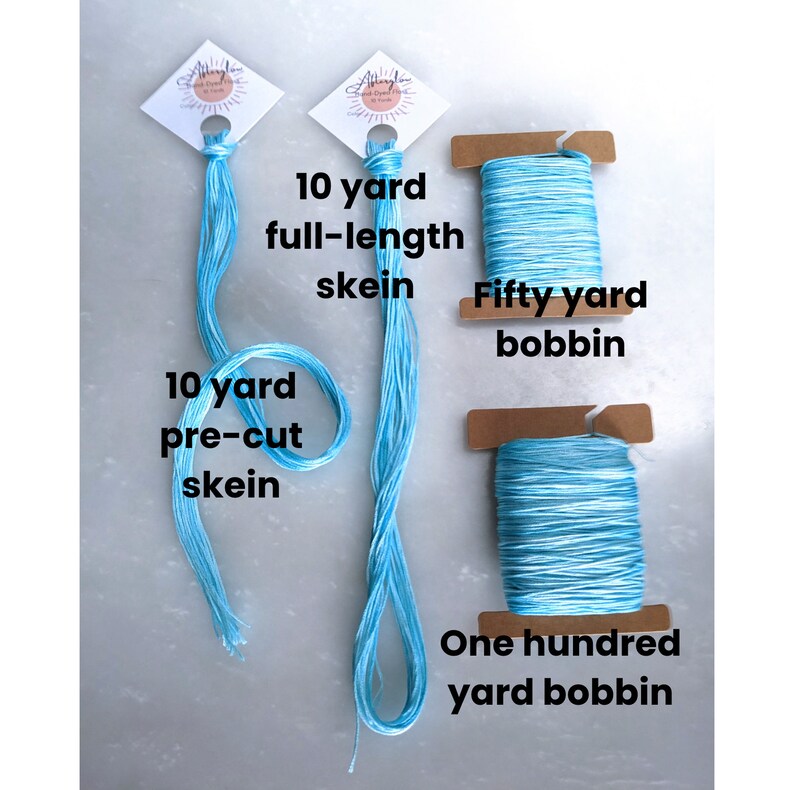 May include: Three spools of blue and white embroidery floss. The spools are labeled with the amount of floss they contain: 10 yard pre-cut skein, 10 yard full-length skein, 50 yard bobbin, and 100 yard bobbin.