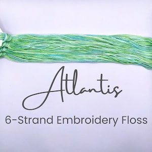 May include: A skein of 6-strand embroidery floss in a green and blue color gradient. The floss is labeled "Atlantis".