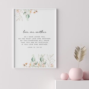 May include: A printable wall art design with a white background and a floral illustration. The text reads "love one another. AS I HAVE LOVED YOU, SO YOU MUST LOVE ONE ANOTHER. BY THIS EVERYONE WILL KNOW THAT YOU ARE MY DISCIPLES, IF YOU LOVE ONE ANOTHER. JOHN 13:34-35"