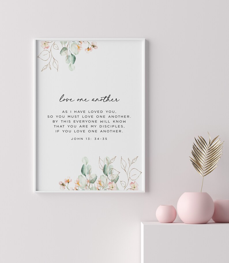 May include: A printable wall art design with a white background and a floral illustration. The text reads "love one another. AS I HAVE LOVED YOU, SO YOU MUST LOVE ONE ANOTHER. BY THIS EVERYONE WILL KNOW THAT YOU ARE MY DISCIPLES, IF YOU LOVE ONE ANOTHER. JOHN 13:34-35"