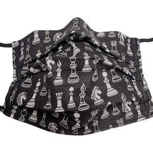 May include: Black face mask with a white chess piece pattern. The mask has elastic ear loops.