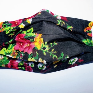 May include: Black face mask with a floral print featuring pink, yellow, and green flowers on a black background.