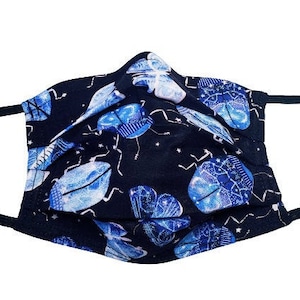 May include: A black face mask with a repeating pattern of blue and white beetles on a black background.