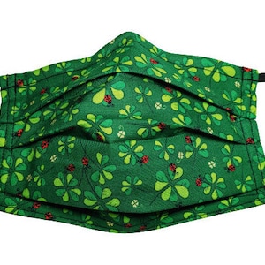May include: Green face mask with a pattern of four-leaf clovers and ladybugs.