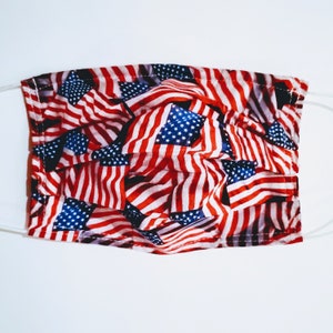 May include: A reusable face mask with a pattern of American flags in red, white, and blue.