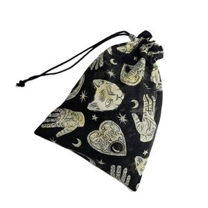 May include: Black drawstring bag with a white and gold print of hands, a cat, stars, and a heart with the text "As Above So Below".