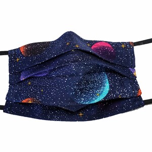May include: A dark blue face mask with a galaxy print featuring colorful planets and stars. The mask has black elastic ear loops.