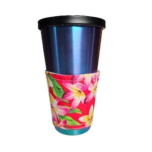 Könnte beinhalten: Ein blauer Edelstahlbecher mit schwarzem Deckel und einer roten Blumenmusterhülle. Die Hülle zeigt rosa, gelbe und weiße Blumen mit grünen Blättern. Der Becher ist so konzipiert, dass er Getränke kalt oder heiß hält.