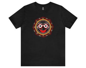 May include: Black t-shirt featuring a red, yellow and white mandala design with a stylised face, two eyes and a smiling mouth.